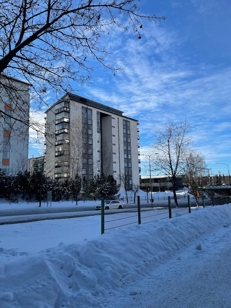 a snow covered road next to a tall building